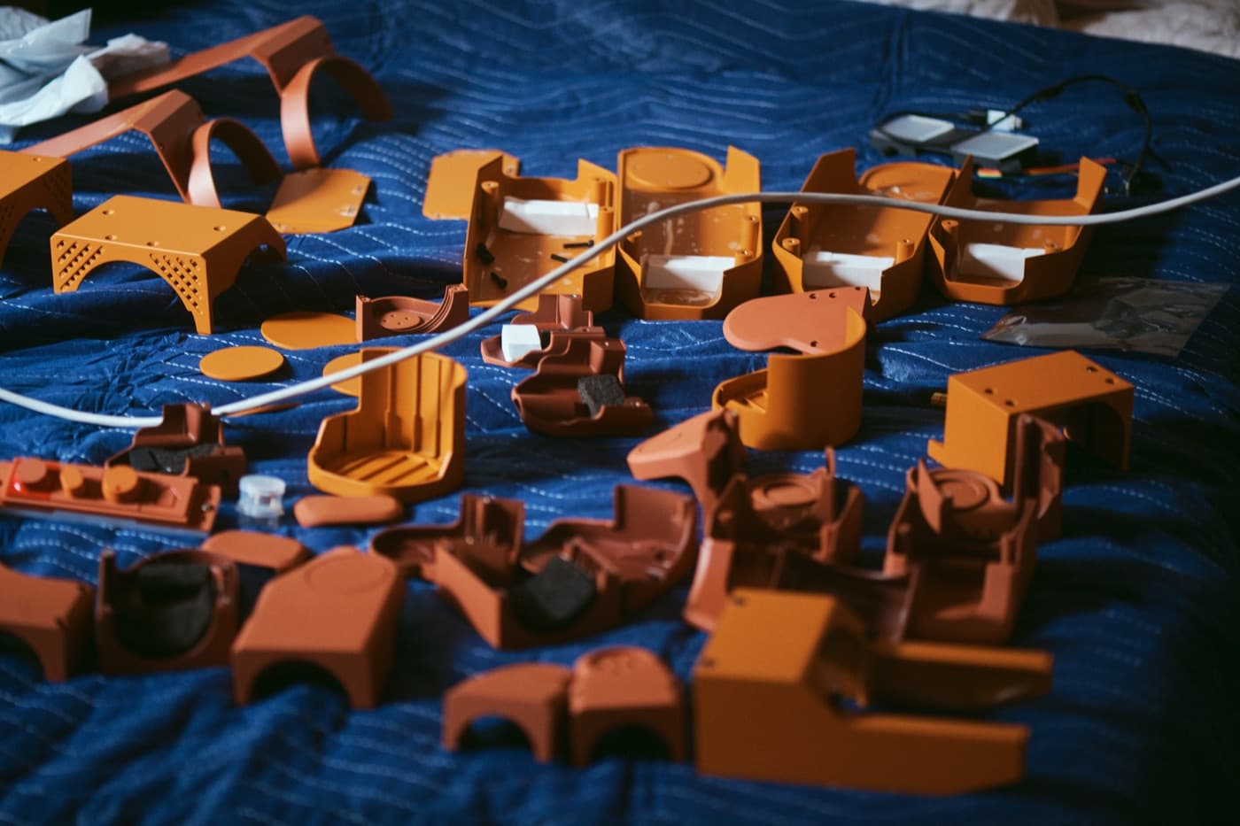 Voxel’s orange shell parts laid out on a blue quilted blanket, waiting to be assembled.